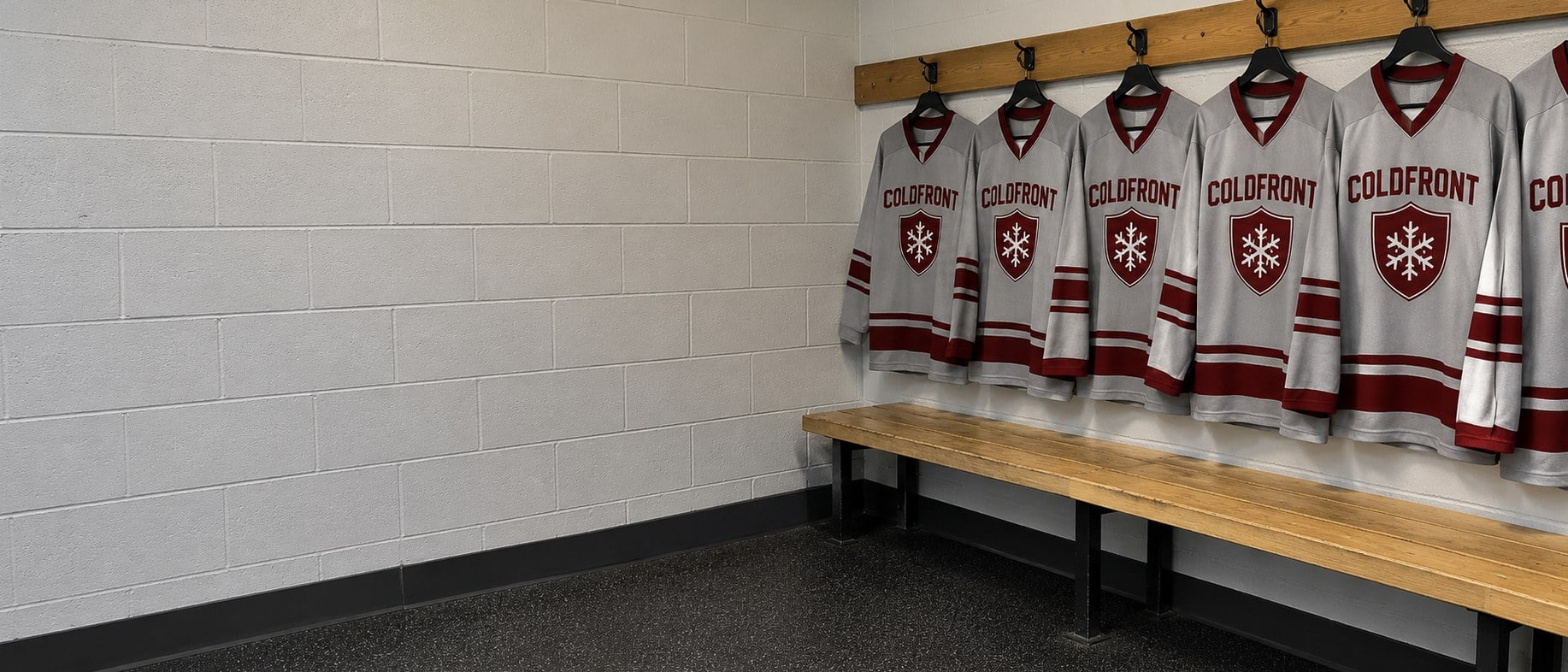 Custom hockey jerseys for a team hanging in a rink locker room